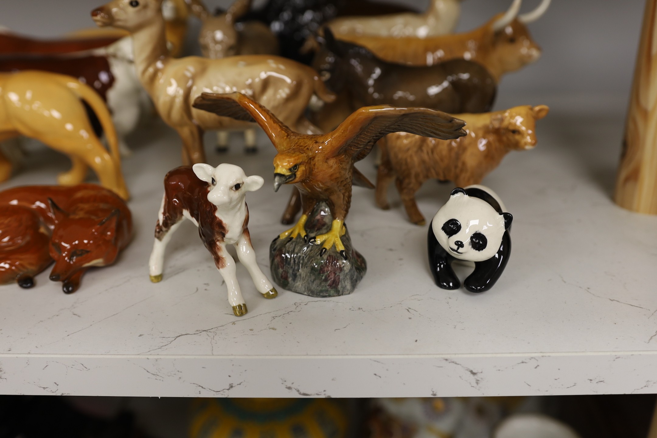 A selection of Beswick animals, to include four bulls and two calves, stag, deer, fawn, fox, panda, falcon, donkey, foal, lioness, lion, and a lion cub (17)